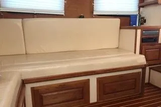 Slide: The Image of 1996 Nordic Tug 32 interior with beige seating and wooden accents. - 15