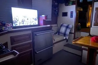 Slide: The Image of Interior of a 1996 Nordic Tug 32, featuring cozy seating and a television. - 18