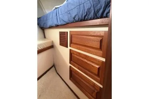 Slide: The Image of Interior of 1996 Nordic Tug 32 with wooden drawers and blue bedding. - 22