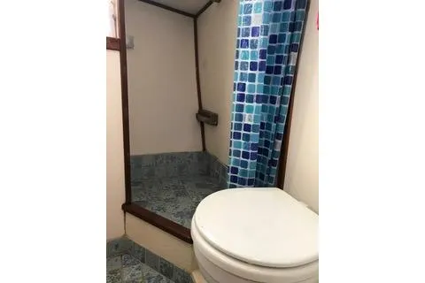 Slide: The Image of Bathroom interior of a 1996 Nordic Tug 32, featuring a shower and toilet. - 23