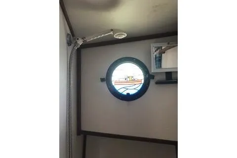 Slide: The Image of 1996 Nordic Tug 32 interior with porthole window and showerhead. - 26