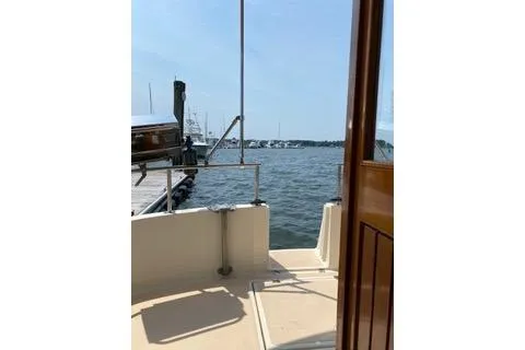 Slide: The Image of 1996 Nordic Tug 32 docked, overlooking a serene marina with calm waters. - 30