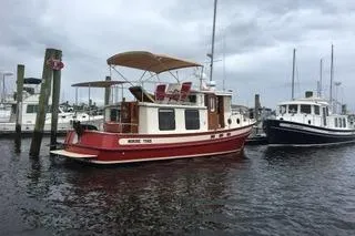 Slide: The Image of 1996 Nordic Tug 32 docked in a marina, overcast sky. - 31