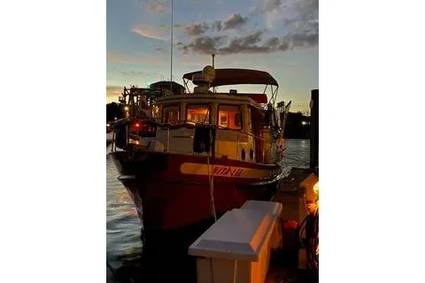 Slide: The Image of 1996 Nordic Tug 32 docked at sunset, illuminated by soft lights. - 32