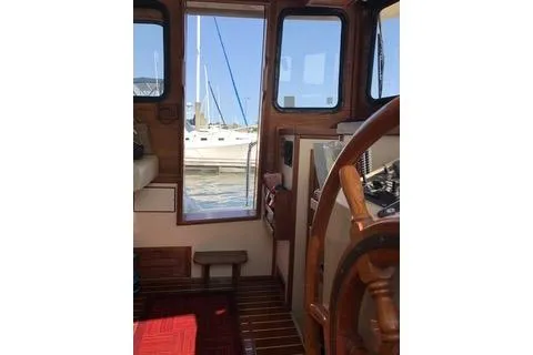 Slide: The Image of Interior view of a 1996 Nordic Tug 32 boat with wooden steering wheel. - 5