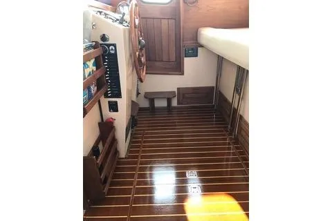 Slide: The Image of Interior of a 1996 Nordic Tug 32 with polished wooden flooring and helm. - 6