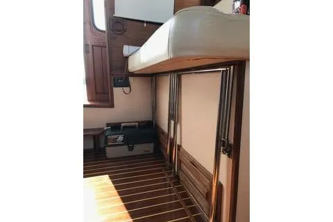 Slide: The Image of Interior of a 1996 Nordic Tug 32, featuring wooden flooring and storage compartments. - 7
