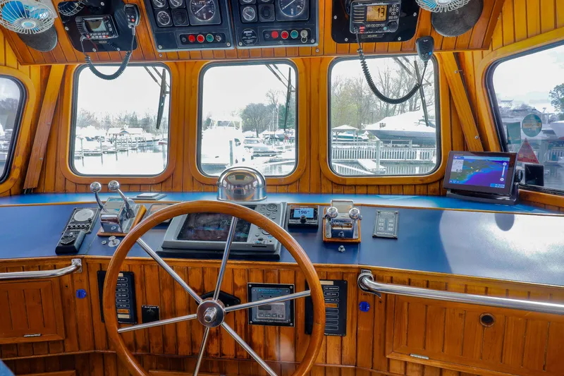 Slide: The Image of Cockpit of 1990 Hans Christian Independance boat with wooden steering wheel and navigation equipment. - 11