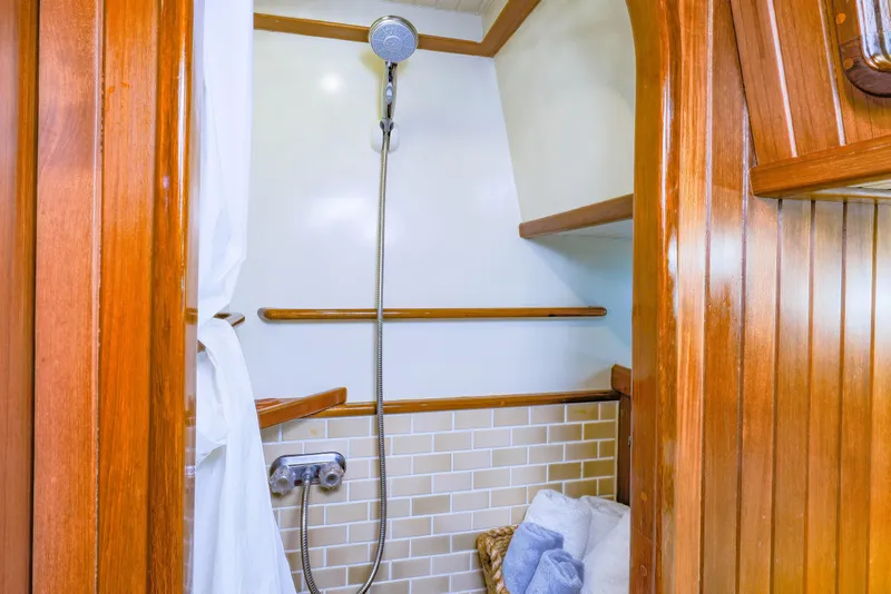 Slide: The Image of Wood-paneled shower area on 1990 Hans Christian Independance yacht, featuring tiled walls and modern fixtures. - 17