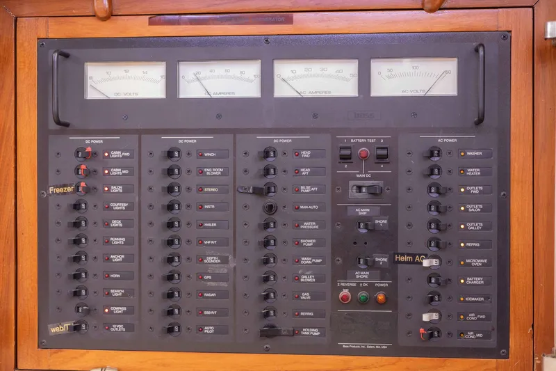 Slide: The Image of Electrical control panel on a 1990 Hans Christian Independance boat, featuring various switches and gauges. - 19