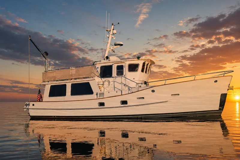 Slide: The Image of Hans Christian 1990 Independence yacht at sunset on calm waters. - 25