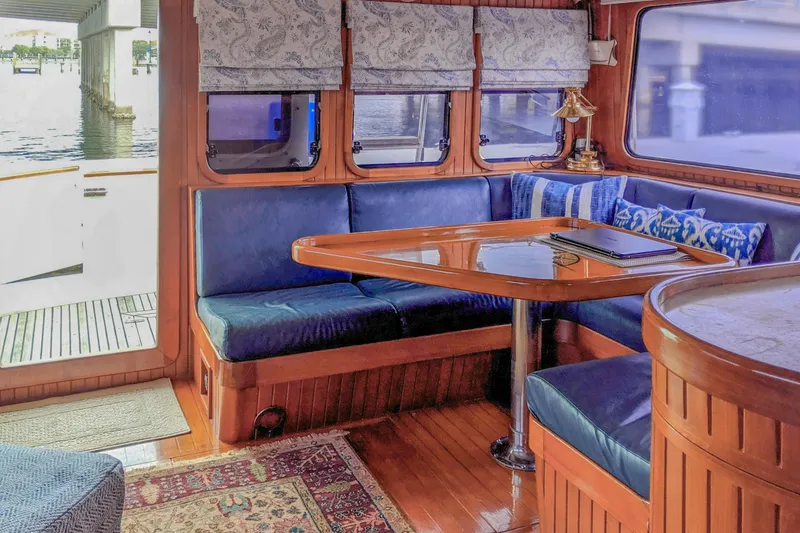 Slide: The Image of Cozy 1990 Hans Christian Independance yacht interior with blue seating and wooden table. - 5