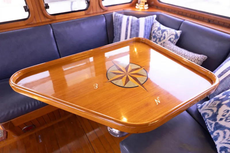 Slide: The Image of Luxurious 1990 Hans Christian Independance yacht interior with compass rose table and plush seating. - 8