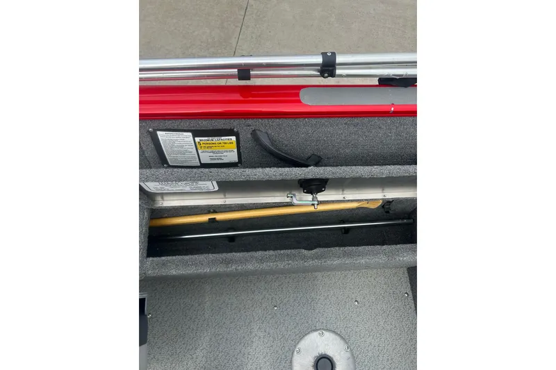 Slide: The Image of 2016 Tracker Pro Guide V-16 SC boat storage compartment with safety labels and equipment. - 18