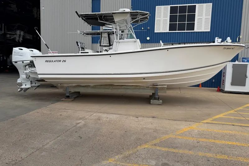 The Image of 1997 Regulator 26 Center Console boat with Suzuki engines, docked at a marina. - 0