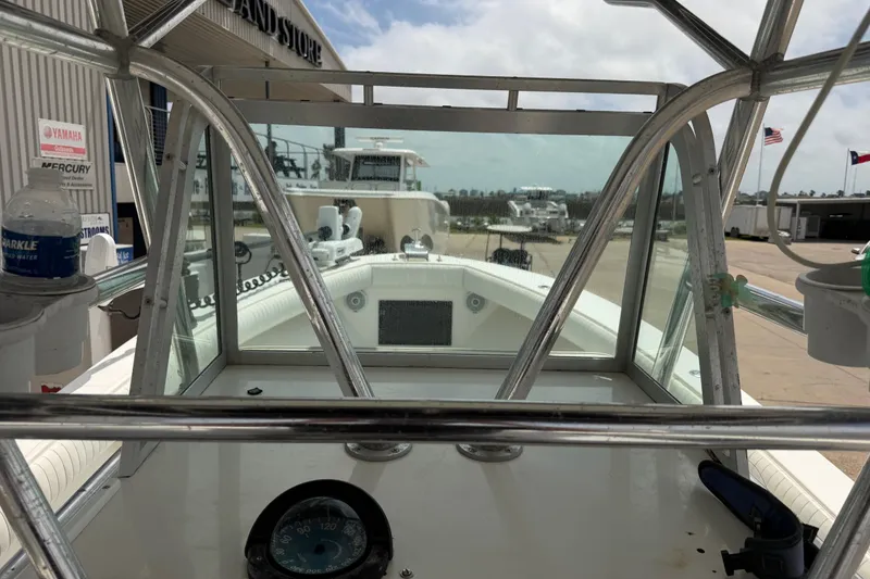 Slide: The Image of 1997 Regulator 26 Center Console boat interior with compass, docked at a marina. - 19