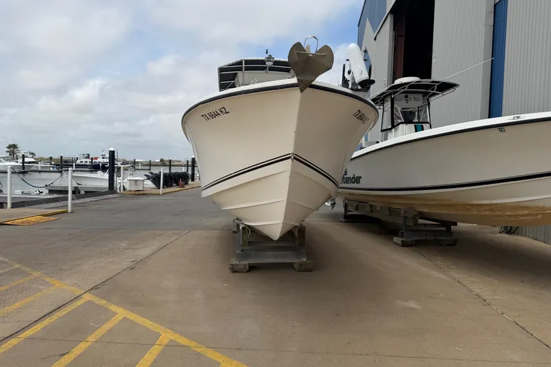 Slide: The Image of 1997 Regulator 26 Center Console boat docked at a marina, front view. - 2