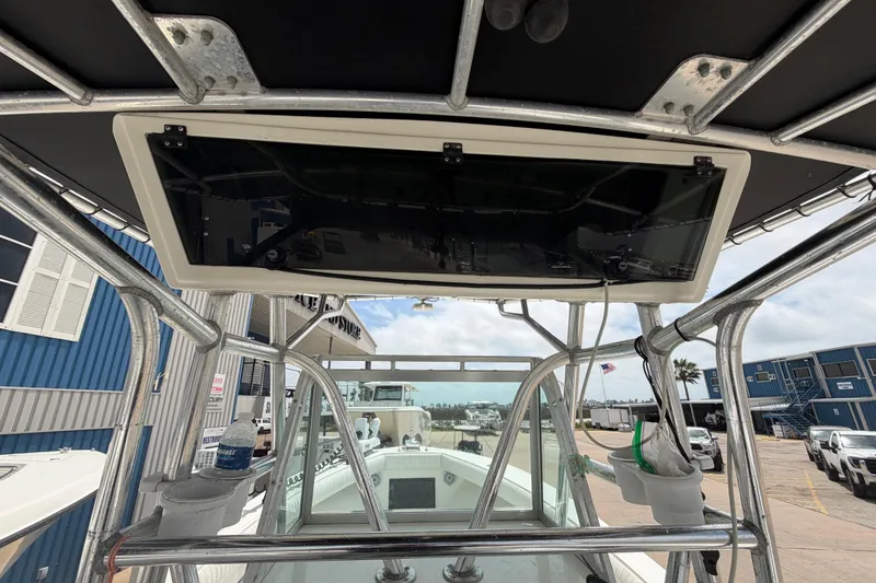 Slide: The Image of 1997 Regulator 26 Center Console boat with T-top and console view at marina. - 23