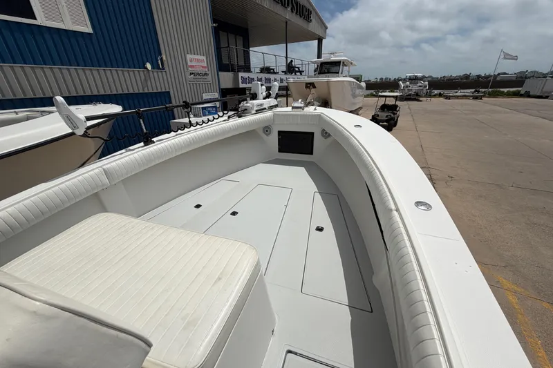Slide: The Image of 1997 Regulator 26 Center Console boat docked at a marina under a cloudy sky. - 26