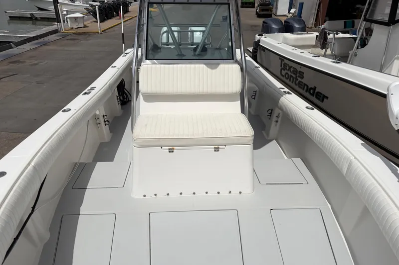 Slide: The Image of 1997 Regulator 26 Center Console boat with white seating and spacious deck at a marina. - 28