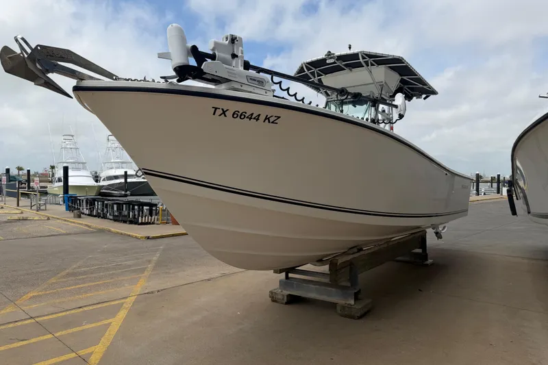 Slide: The Image of 1997 Regulator 26 Center Console boat on dock, side view with registration number TX 6644 KZ. - 3