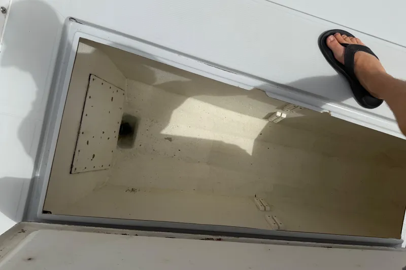 Slide: The Image of Open storage compartment on a 1997 Regulator 26 Center Console boat deck. - 32
