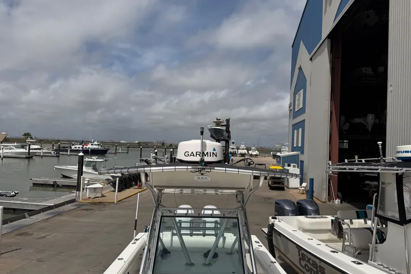 Slide: The Image of 1997 Regulator 26 Center Console boat docked near a marina with cloudy skies. - 33
