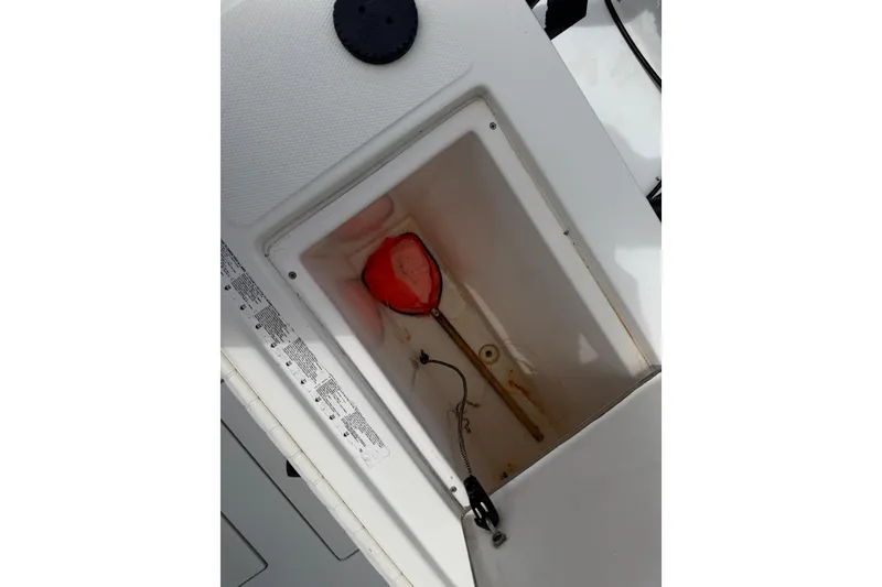 Slide: The Image of Storage compartment of a 1997 Regulator 26 Center Console boat with a red net inside. - 39