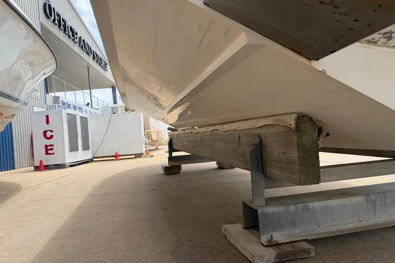 Slide: The Image of 1997 Regulator 26 Center Console boat on trailer near ice machine and store. - 43