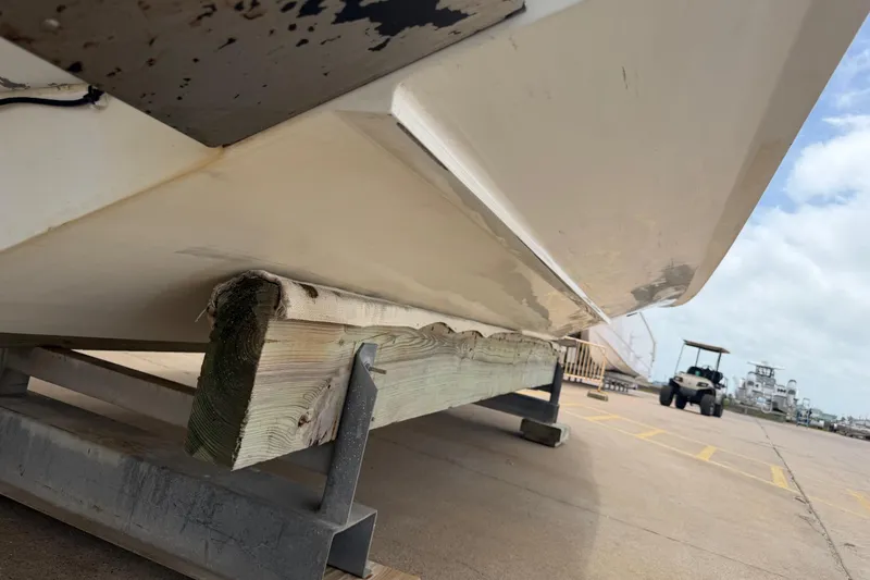 Slide: The Image of 1997 Regulator 26 Center Console boat on wooden support at a marina. - 44