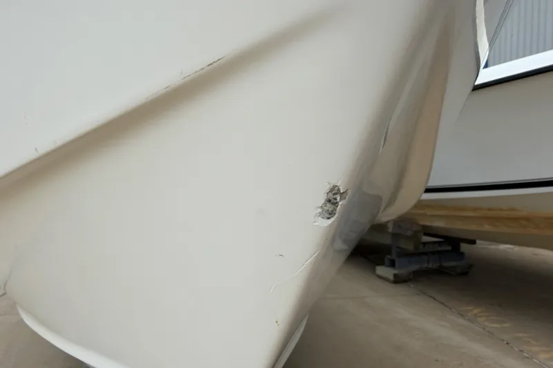 Slide: The Image of Damaged hull of 1997 Regulator 26 Center Console boat on dry dock. - 45