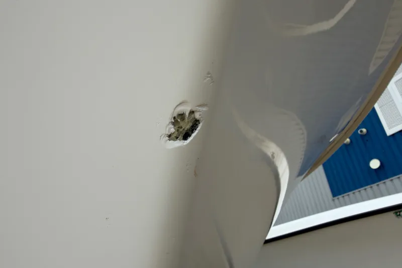 Slide: The Image of Damaged hull of 1997 Regulator 26 Center Console boat with visible hole. - 46