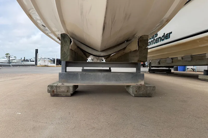 Slide: The Image of 1997 Regulator 26 Center Console boat on a wooden and metal stand at a marina. - 49