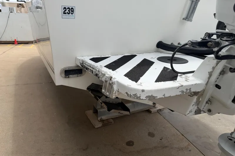 Slide: The Image of 1997 Regulator 26 Center Console boat stern with visible wear and dock number 239. - 52