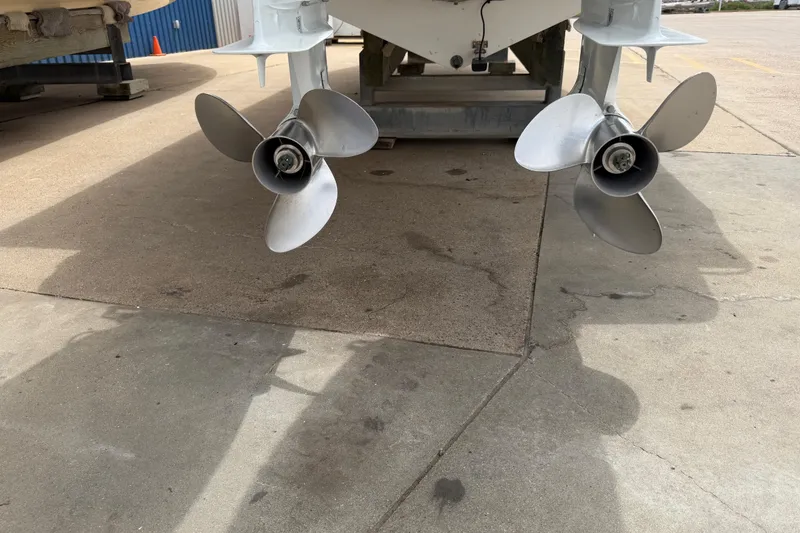 Slide: The Image of Twin propellers of a 1997 Regulator 26 Center Console boat on a concrete surface. - 6