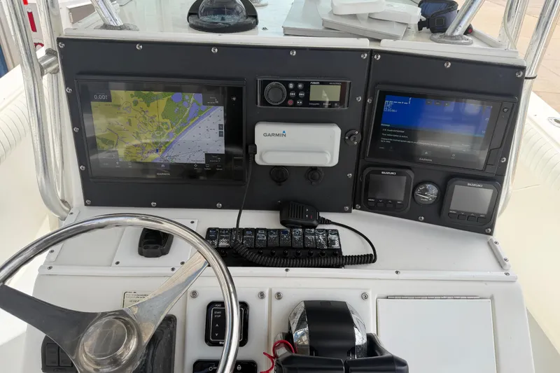 Slide: The Image of 1997 Regulator 26 Center Console boat dashboard with Garmin navigation displays and controls. - 7