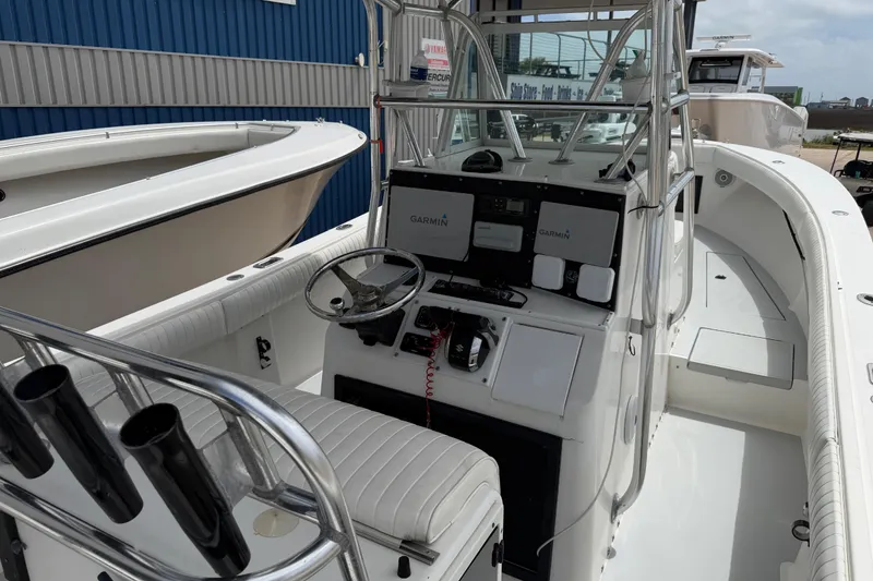 Slide: The Image of 1997 Regulator 26 Center Console boat with Garmin navigation, docked at a marina. - 9