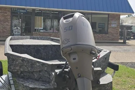 Slide: The Image of 2026 Havoc 1553 VJST boat with outboard motor in front of a store. - 1