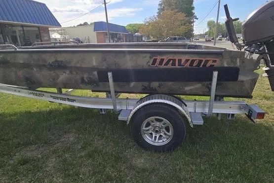 The Image of 2026 Havoc 1860 DBST boat on trailer, parked on grass near a building. - 1