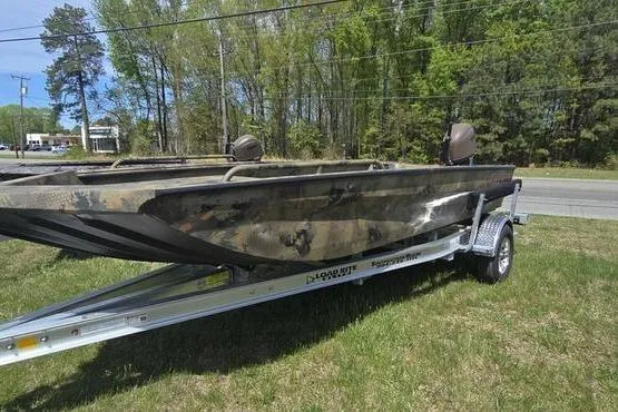 Slide: The Image of 2026 Havoc 1860 DBST boat on trailer, camo design, parked on grass by roadside. - 10