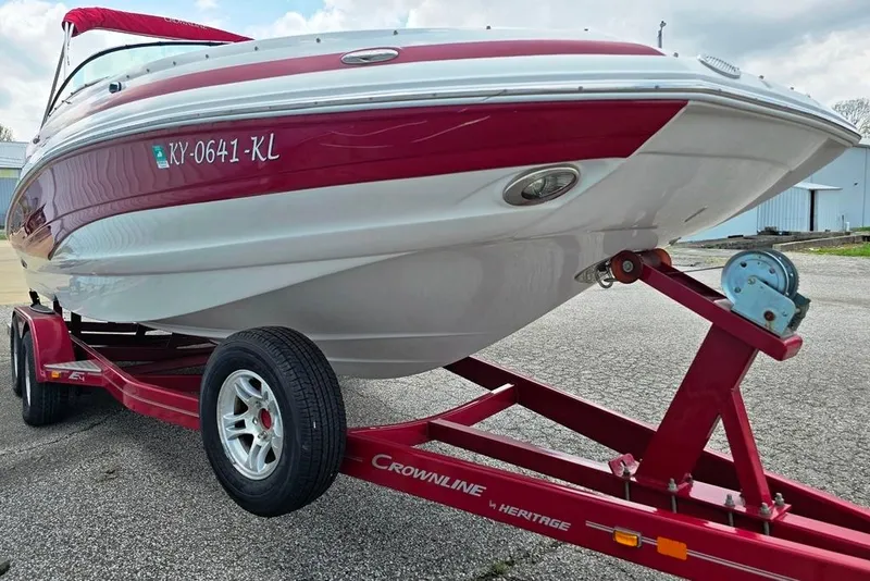 Slide: The Image of 2012 Crownline Eclipse E4 boat on red trailer, parked outdoors. - 14