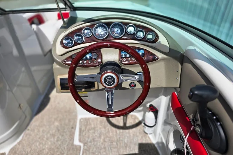 Slide: The Image of Steering wheel and dashboard of a 2012 Crownline Eclipse E4 boat, featuring gauges and controls. - 19