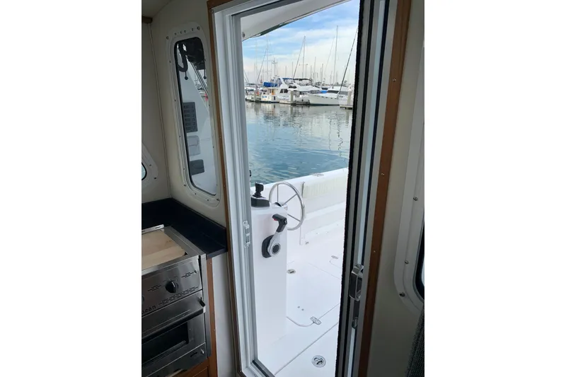 Slide: The Image of Interior view of 2026 SeaSport Offshore 3000 boat, showing open door to marina. - 15