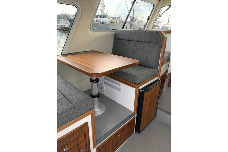 Slide: The Image of Interior of 2026 SeaSport Offshore 3000 boat with wooden table and cushioned seating. - 18
