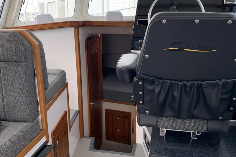 Slide: The Image of Interior of 2026 SeaSport Offshore 3000 boat, featuring helm seat and cabin entrance. - 19