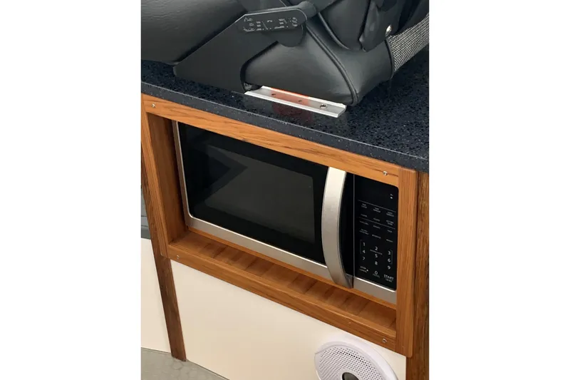 Slide: The Image of Microwave in 2026 SeaSport Offshore 3000 boat interior, featuring wood cabinetry and modern design. - 20