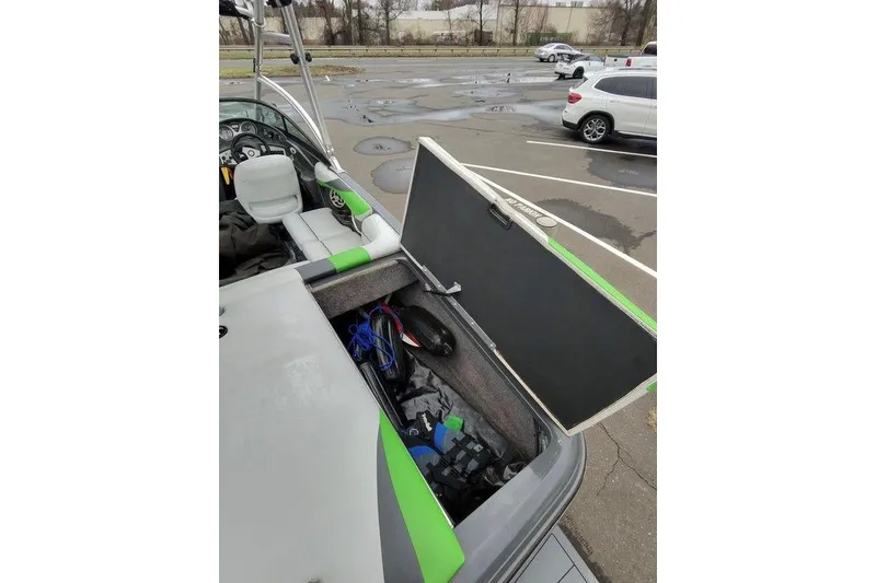 Slide: The Image of 2009 Moomba Mobius LSV boat with open storage compartment in a parking lot. - 8