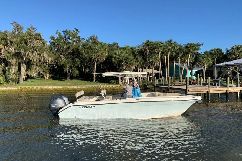 The Image of 2017 Century 2600 Center Console boat on water near a dock, surrounded by trees. - 0