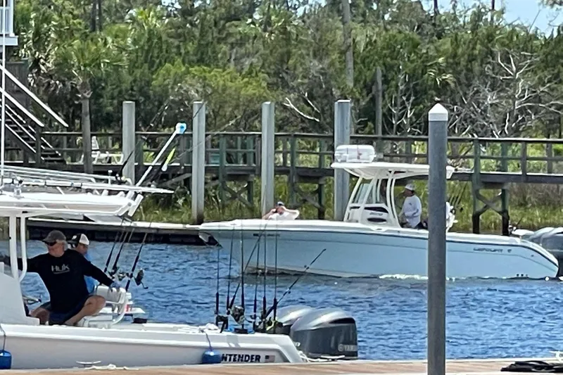 Slide: The Image of 2017 Century 2600 Center Console boat docked near a marina with fishing gear. - 14