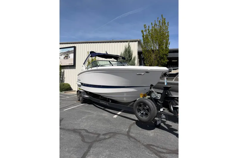 Slide: The Image of 2023 Chaparral 287 SSX boat on trailer in parking lot, sunny day. - 2